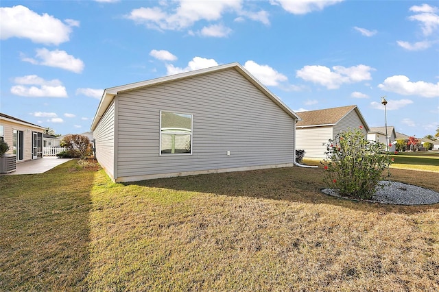 view of side of home with a yard