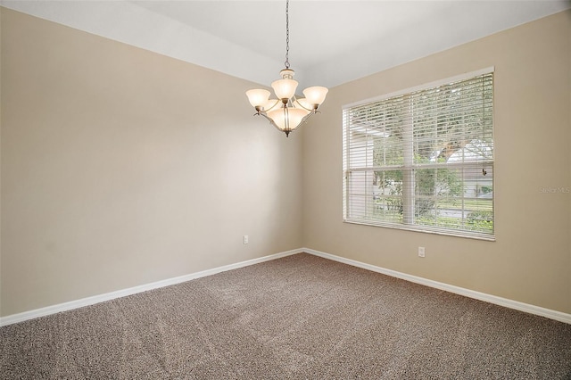 unfurnished room featuring carpet and a chandelier