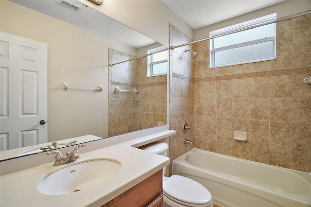 full bathroom featuring toilet, vanity, and tiled shower / bath