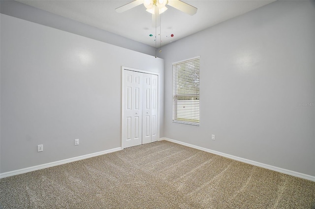 unfurnished bedroom with ceiling fan, a closet, and carpet flooring