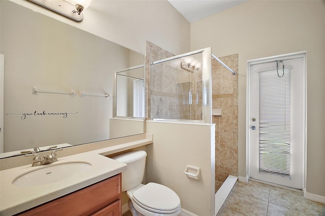 bathroom featuring toilet, tile patterned flooring, a tile shower, and vanity