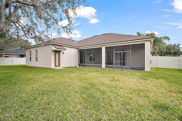 back of property with a yard and a sunroom