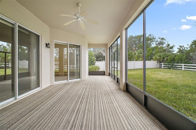 unfurnished sunroom with ceiling fan