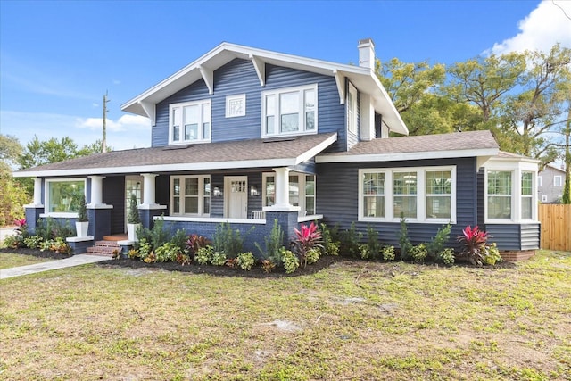 view of front of house featuring covered porch and a front lawn