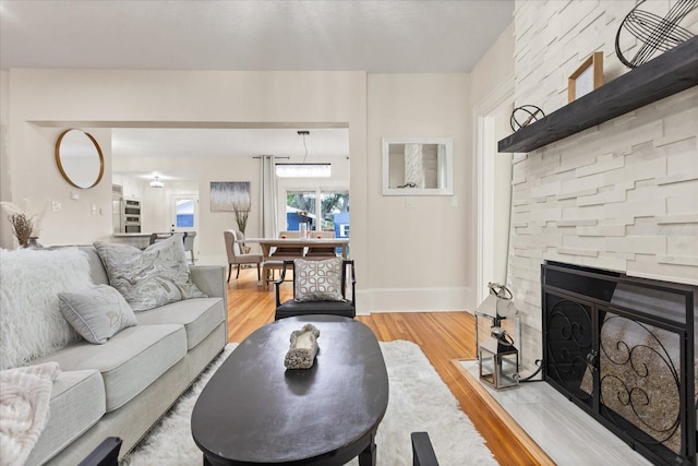 living room featuring light hardwood / wood-style flooring and a stone fireplace