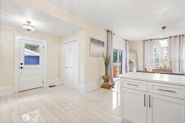 kitchen with white cabinetry, pendant lighting, and plenty of natural light