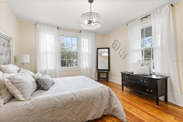 bedroom featuring wood-type flooring and a chandelier