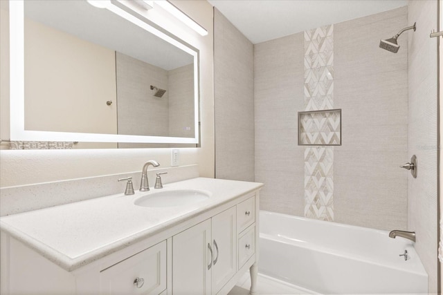 bathroom with tiled shower / bath combo and vanity