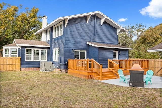 rear view of property featuring a patio, a wooden deck, and a yard