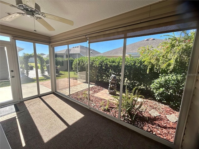 unfurnished sunroom featuring ceiling fan