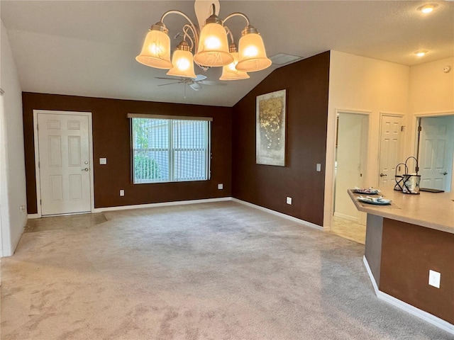 unfurnished living room featuring light carpet, ceiling fan with notable chandelier, and lofted ceiling