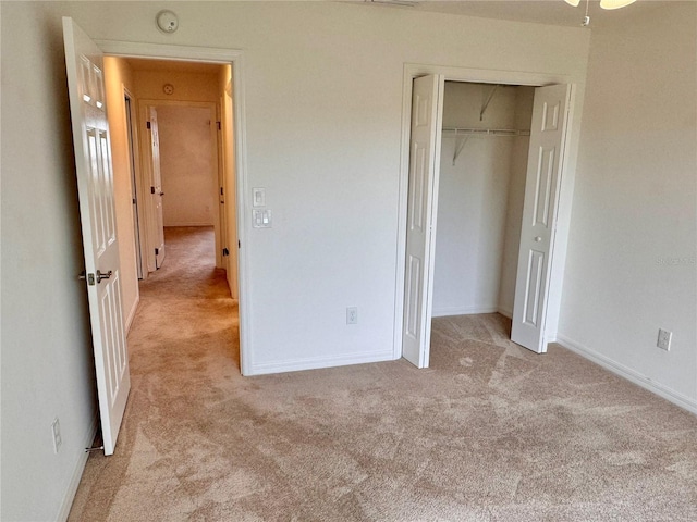 unfurnished bedroom with light colored carpet and a closet