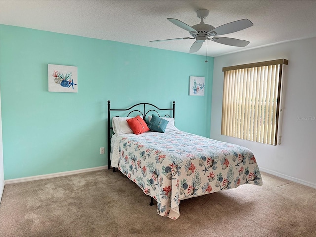 carpeted bedroom featuring a textured ceiling and ceiling fan