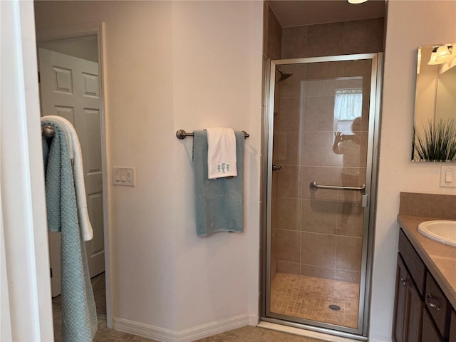 bathroom featuring vanity, a shower with shower door, and tile patterned floors