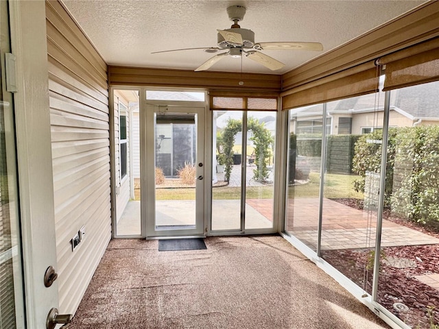 unfurnished sunroom featuring ceiling fan