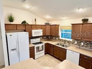 kitchen featuring visible vents, white appliances, decorative backsplash, and vaulted ceiling