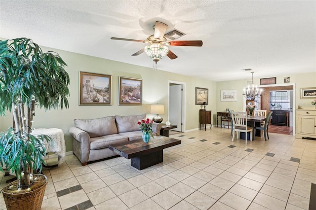 tiled living room with a textured ceiling and ceiling fan with notable chandelier