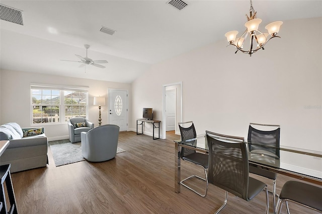 living room with ceiling fan with notable chandelier, dark hardwood / wood-style flooring, and vaulted ceiling