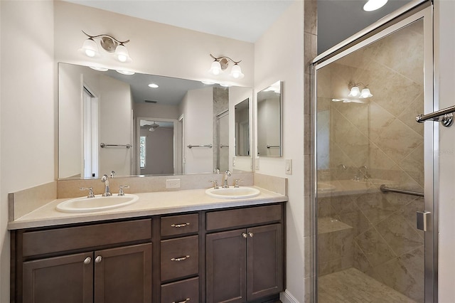 bathroom featuring a shower with shower door and vanity