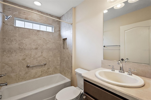 full bathroom featuring tiled shower / bath combo, vanity, and toilet