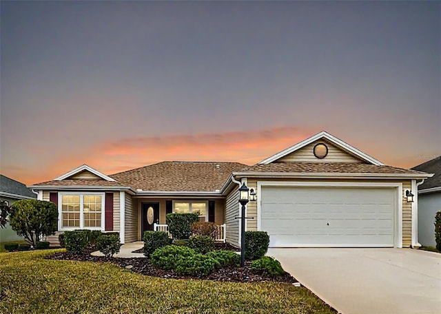 ranch-style home featuring a garage and a lawn