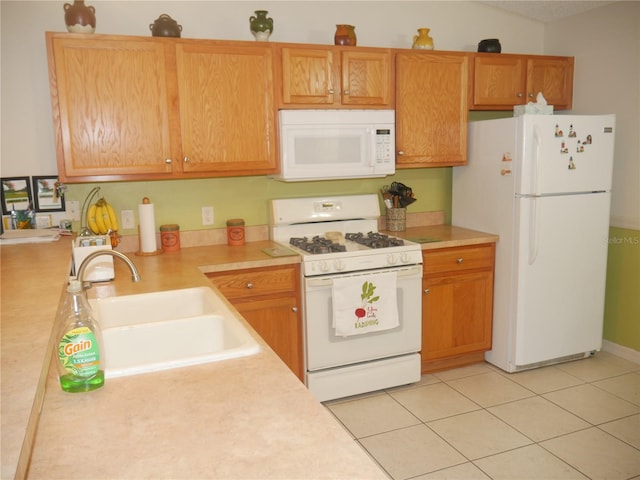 kitchen with white appliances, light tile patterned flooring, and sink