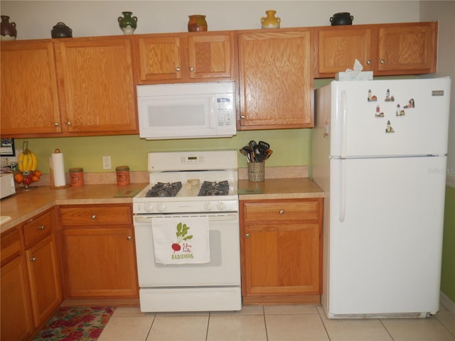 kitchen with white appliances and light tile patterned floors