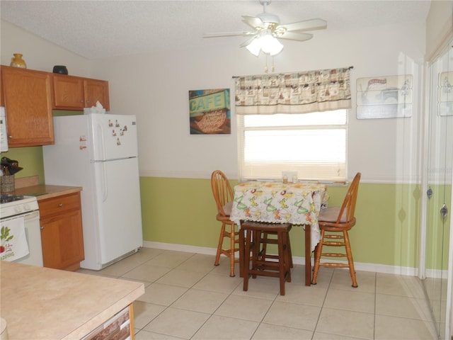 kitchen with white appliances, ceiling fan, a textured ceiling, and light tile patterned floors