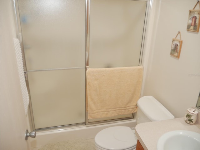 bathroom featuring vanity, a shower with shower door, and toilet