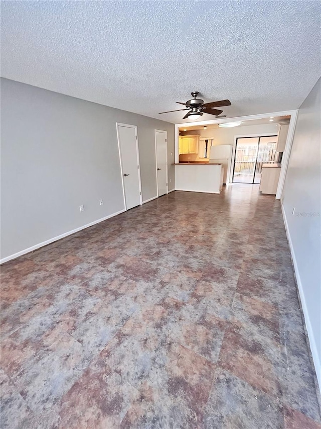 unfurnished living room with ceiling fan and a textured ceiling