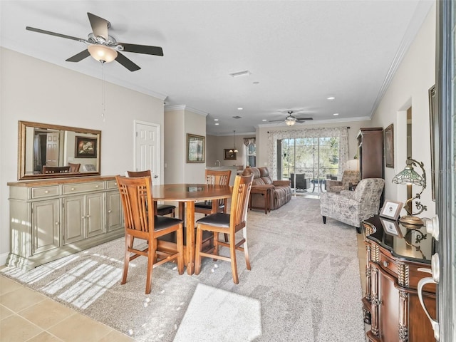 dining room featuring light carpet, ceiling fan, and ornamental molding