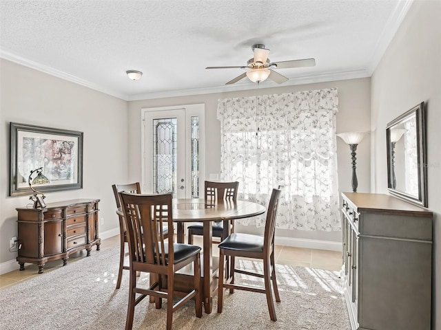 carpeted dining room featuring ceiling fan, a textured ceiling, and ornamental molding