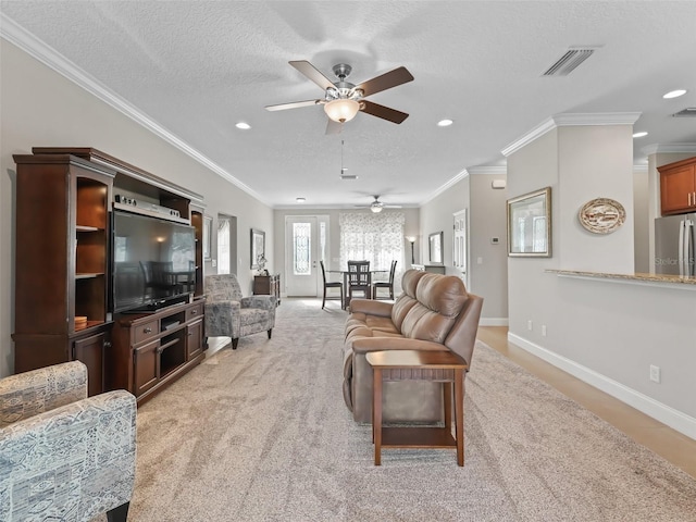 carpeted living room featuring a textured ceiling, ceiling fan, and ornamental molding