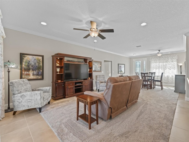 tiled living room with a textured ceiling, ceiling fan, and ornamental molding