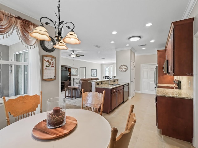 tiled dining room with crown molding, ceiling fan with notable chandelier, and sink