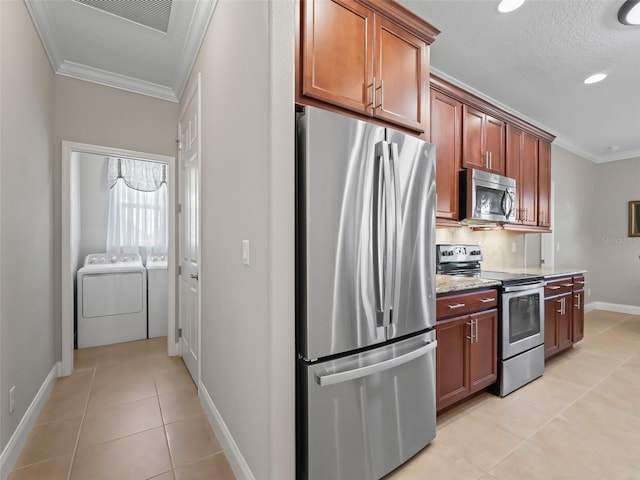 kitchen featuring light tile patterned floors, separate washer and dryer, stainless steel appliances, and crown molding