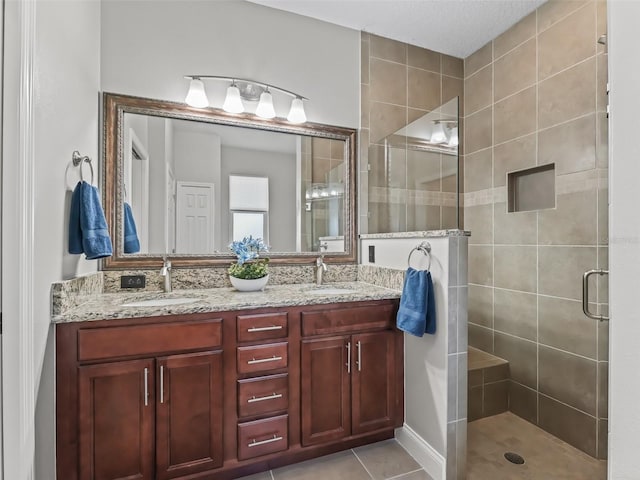 bathroom featuring tile patterned floors, a shower with shower door, and vanity