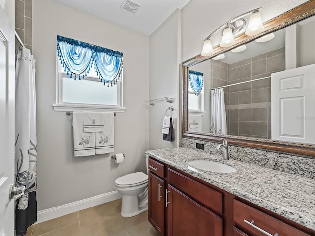 bathroom featuring tile patterned floors, vanity, toilet, and a healthy amount of sunlight