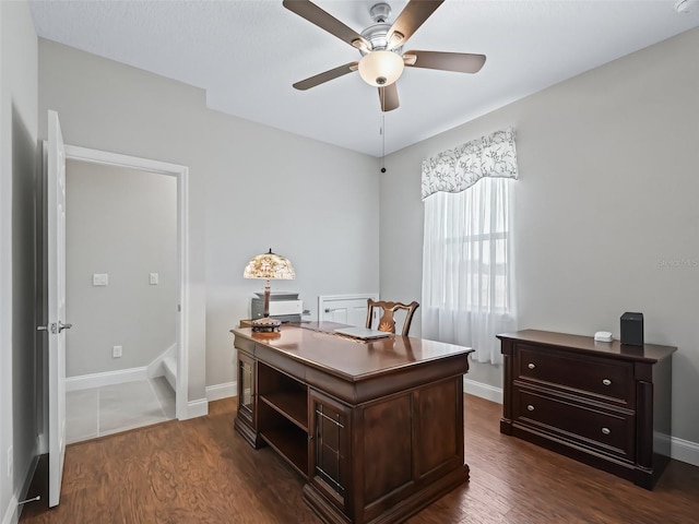 home office with ceiling fan and dark hardwood / wood-style flooring