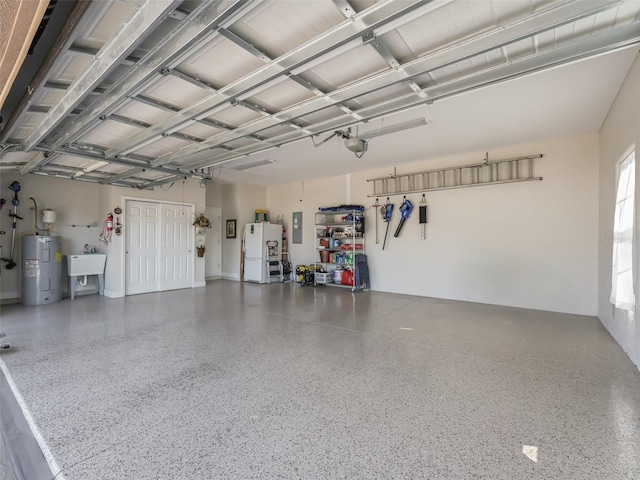 garage featuring electric water heater, sink, a garage door opener, and white fridge