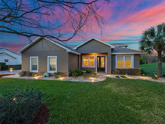 ranch-style home with a lawn