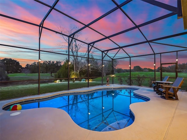 pool at dusk featuring glass enclosure, a patio area, and a lawn