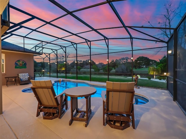 pool at dusk with a patio area and glass enclosure