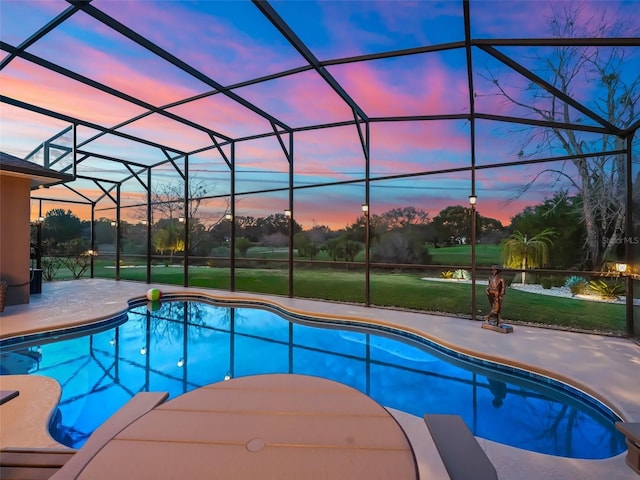 pool at dusk with a yard, a patio, and glass enclosure