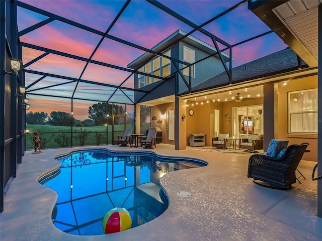 pool at dusk with a patio area and a lanai