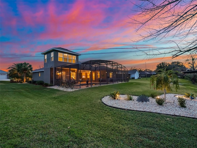 back house at dusk with a yard and glass enclosure