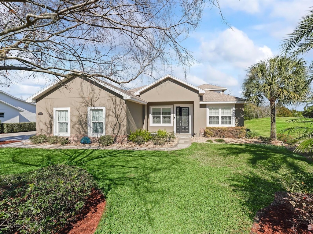 view of front of home featuring stucco siding and a front lawn