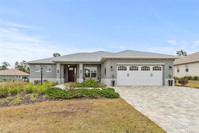 prairie-style house with a garage and a front lawn