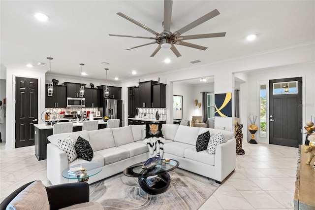 living room with crown molding and ceiling fan