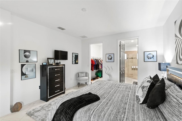 bedroom with ensuite bath, a spacious closet, and a closet